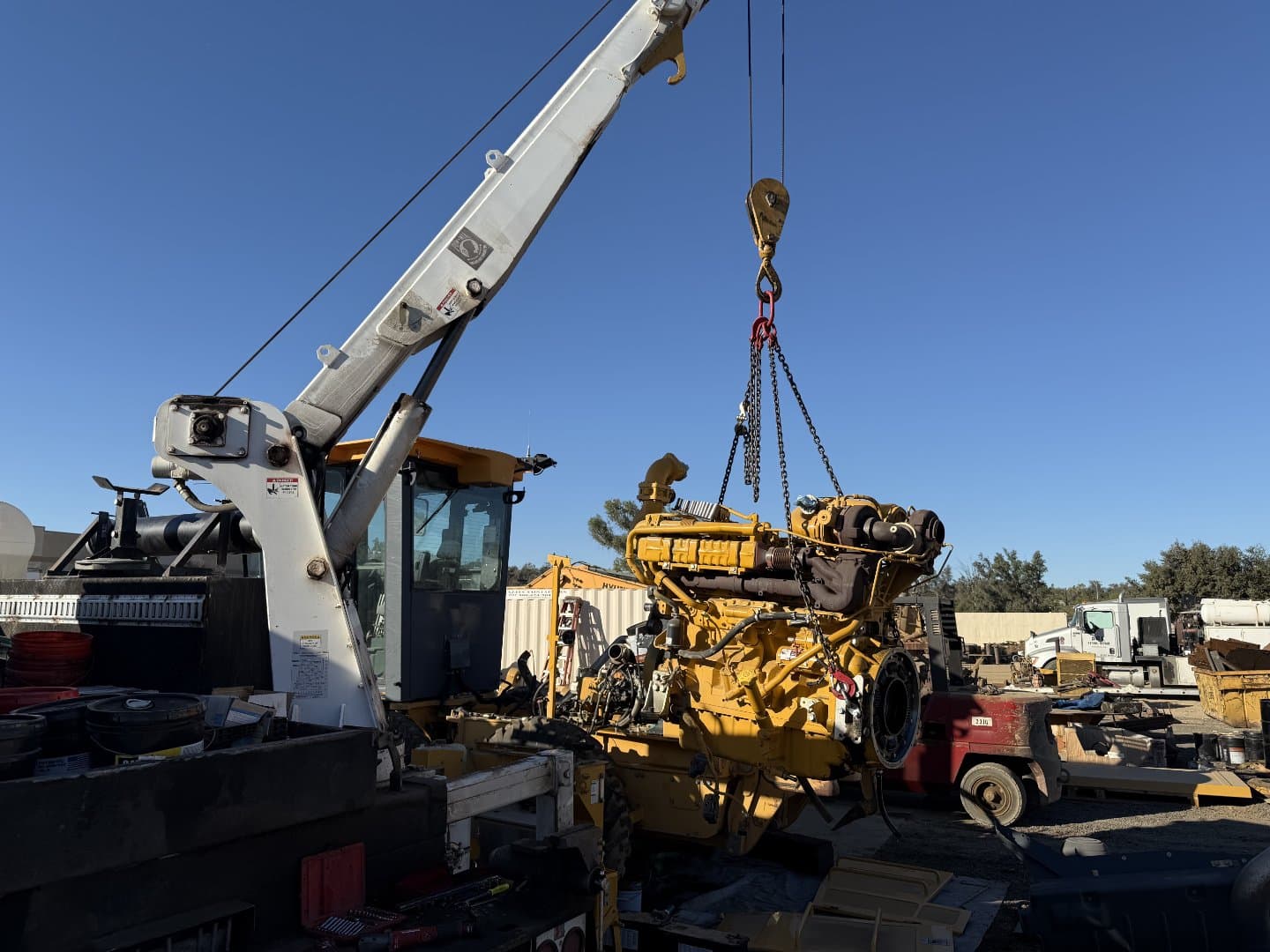 Heavy equipment engine being lifted during field service